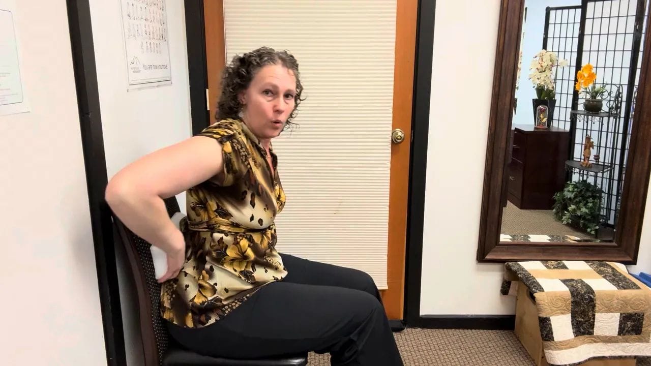 Demonstration of sitting on sit bones versus tailbone when leaning back in a chair.